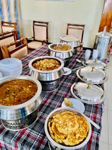 ein Tisch mit mehreren Tabletten Essen drauf in der Unterkunft Plaza Inn Hotel in Rahimyar Khan
