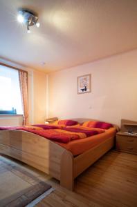 Un dormitorio con una gran cama de madera con almohadas rojas en Ferienhaus Schaumbergblick, en Britten
