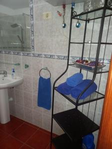 uma casa de banho com um chuveiro, um lavatório e uma toalha azul em Casa Ramos em Arrecife