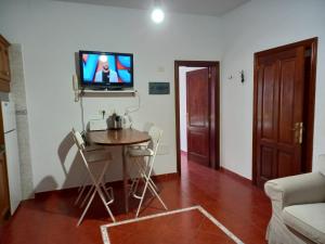 uma sala de estar com uma mesa e uma televisão na parede em Casa Ramos em Arrecife