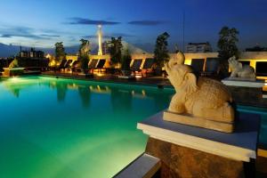 a swimming pool with a statue in front of it at Rambuttri Village Plaza in Bangkok