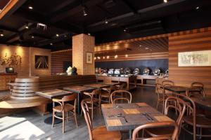 a restaurant with wooden tables and chairs and a counter at Rambuttri Village Plaza in Bangkok
