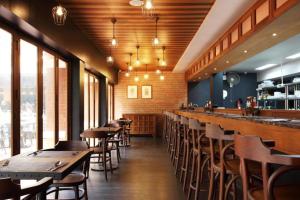 a restaurant with wooden tables and chairs and windows at Rambuttri Village Plaza in Bangkok