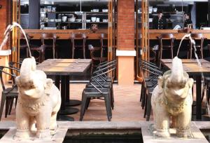 two statues of elephants in front of a table and chairs at Rambuttri Village Plaza in Bangkok