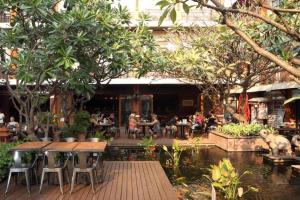 a group of people sitting at tables in a restaurant at Rambuttri Village Plaza in Bangkok