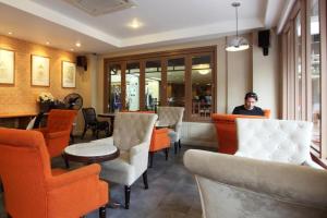 a man sitting in a restaurant with orange chairs at Rambuttri Village Plaza in Bangkok