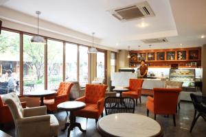 a restaurant with orange chairs and tables and a counter at Rambuttri Village Plaza in Bangkok