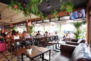 a group of people sitting at tables in a restaurant at Rambuttri Village Plaza in Bangkok