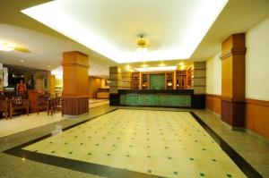 a large room with a tile floor with a swimming pool at Rambuttri Village Plaza in Bangkok