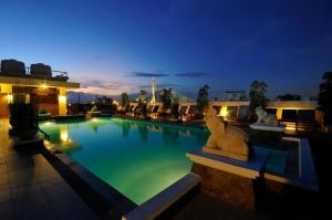 a swimming pool with a lion statue next to a building at Rambuttri Village Plaza in Bangkok