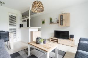a living room with a tv and a table at Appartement NoorderKragt, Amelander Kaap in Hollum