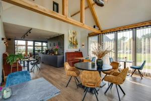 a dining room with tables and chairs and windows at Op dn Kreijtenberg in Milheeze
