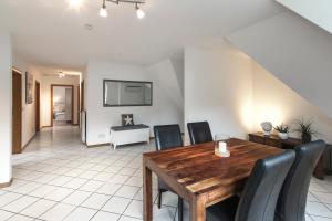 a dining room with a wooden table and black chairs at Arkadia-Home-Hamburg-Airport-Apartment in Hamburg