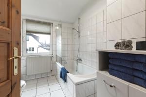 ein Badezimmer mit einer Badewanne, einem WC und einem Waschbecken in der Unterkunft Arkadia-Home-Hamburg-Airport-Apartment in Hamburg