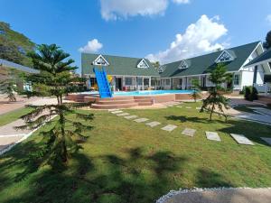 une maison avec un toboggan bleu devant elle dans l'établissement English Resotel : อิงลิช รีโซเทล, à Nakhon Si Thammarat