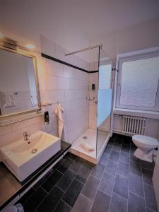 a bathroom with a sink and a shower and a toilet at Arena Hotel in Gelsenkirchen