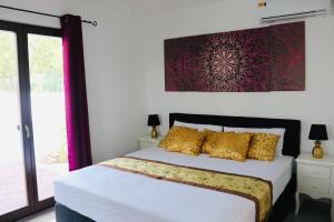 een slaapkamer met een groot bed met gele kussens bij NEW HOUSE TROPIC PARADISE with Pool in Willemstad