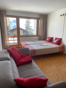 a living room with two beds and a couch at Rose des Alpes in Leysin