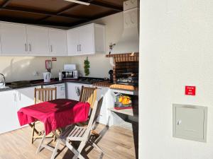 a kitchen with a table and chairs in a kitchen at SLICE OF PONTA DO SOL- GROUND FLOOR- SEA VIEW in Ponta do Sol