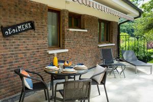 a patio with a table and chairs and a brick wall at Casa Rural Oroimena in Andoain