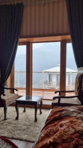 a bedroom with a large window with a view of the ocean at The Swat House in Swat