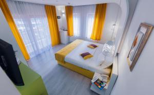 um pequeno quarto com uma cama com cortinas amarelas em Hotel Boutique Libris em Sarajevo