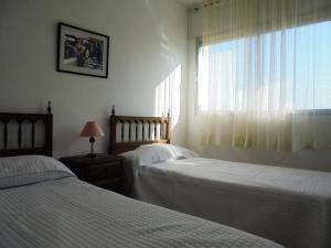 a bedroom with two beds and a window at Residencial Peñiscola Playa 4/6 LEK in Peñíscola