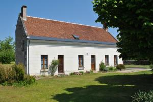 an old white house with a brown roof at Le Tulipier de Virginie in Noyers-sur-Cher