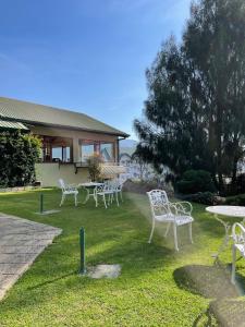 a group of white chairs and tables in a yard at Tea Bush Hotel in Nuwara Eliya