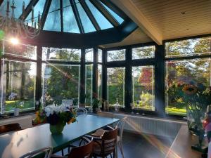 a room with a table and a bunch of windows at Au Clos Caleste in Wellin