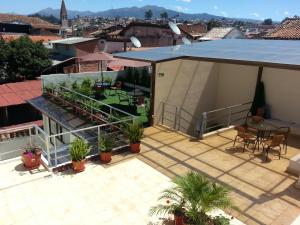 a patio with plants and a table on a roof at Hostal Casa de Lidice in Cuenca
