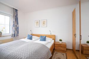 ein Schlafzimmer mit einem großen Bett mit blauen Kissen in der Unterkunft Seepark Wohnung 2 1 in Scharbeutz