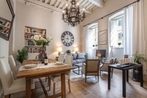 uma sala de estar com uma mesa e uma sala de jantar em Casa Janca, Find sanctuary at extraordinary rates! Luxury Smart Apartment in Central Lucca em Lucca