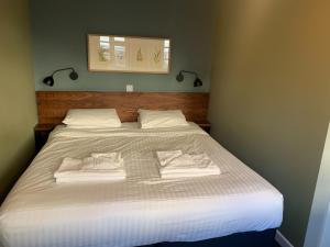 ein Schlafzimmer mit einem großen Bett mit Handtüchern darauf in der Unterkunft The Old Ship Inn in Dorchester