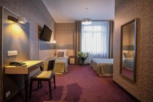 pokój hotelowy z dwoma łóżkami, biurkiem i lustrem w obiekcie Hotel Kazimierz w Krakowie