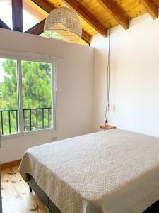 a bedroom with a bed and a large window at Cabañas Sonnenblumen in Potrero de Garay