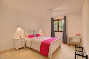 - une chambre avec un lit doté d'oreillers roses et d'une fenêtre dans l'établissement Apartamentos Los Enanos La Palma, à Santa Cruz de la Palma