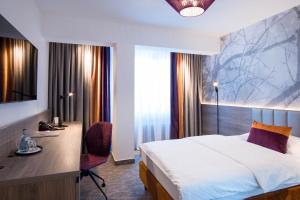 una camera d'albergo con letto, scrivania e finestra di Hotel Boehler a Böblingen