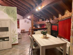 a dining room with a table and a kitchen at BALMA DEI CUP con SPA privata su richiesta in Pont Canavese