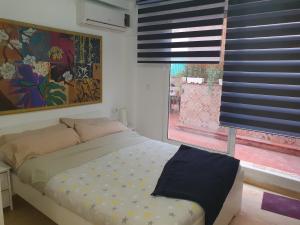 Schlafzimmer mit einem Bett und einem Fenster mit blauen Jalousien in der Unterkunft Apartamentos Naranja y Limòn in Valencia