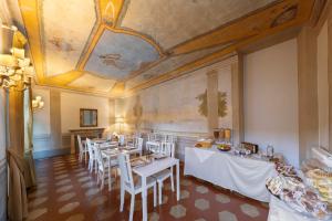 uma sala de jantar com mesas e cadeiras e um tecto em B&B I Quattro Poeti em Florença