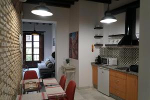 a kitchen and living room with a table and chairs at Balcón Giralda Center & Sweet in Seville