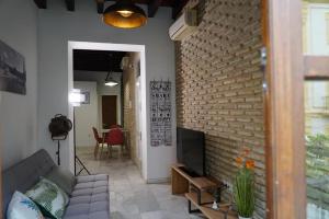 a living room with a couch and a brick wall at Balcón Giralda Center & Sweet in Seville