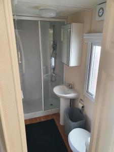 La petite salle de bains est pourvue d'une douche et d'un lavabo. dans l'établissement RBR 662 - Beach Resort Kamperland, à Kamperland