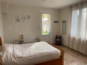 1 dormitorio con cama blanca y ventana en Chambre au bruand, en Saint-Porchaire