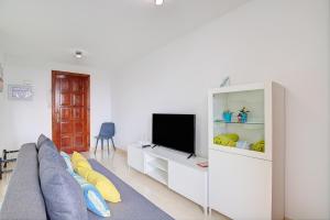 un salon avec un canapé et une télévision dans l'établissement Apartamentos Los Enanos La Palma, à Santa Cruz de la Palma