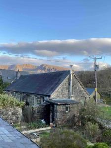 an old stone house with mountains in the background at Panoramic Mountain Retreat - Waen Fechan - 4x4 access only in Dolgellau