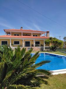 a villa with a swimming pool in front of a house at Quinta Do Ribeirinho in Vilar da Mó