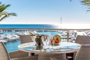 una mesa con un bol de fruta y vasos en el balcón en Front Line Penthouse Puerto Banus With Sea Views, en Marbella