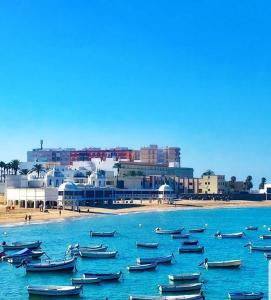 un grupo de barcos en el agua cerca de una playa en El rincón de la Caleta, en Cádiz